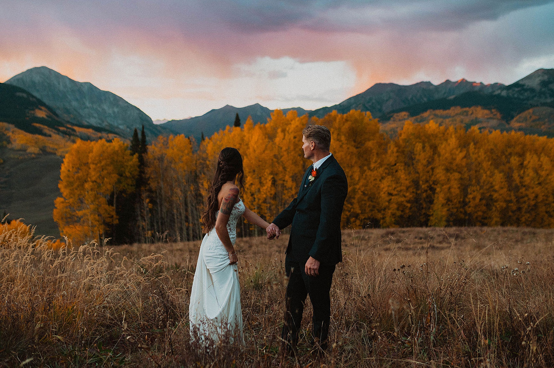 bride and groom on their wedding day at Ten peaks, overlooking the mountains at sunset at the Crested Butte Resort