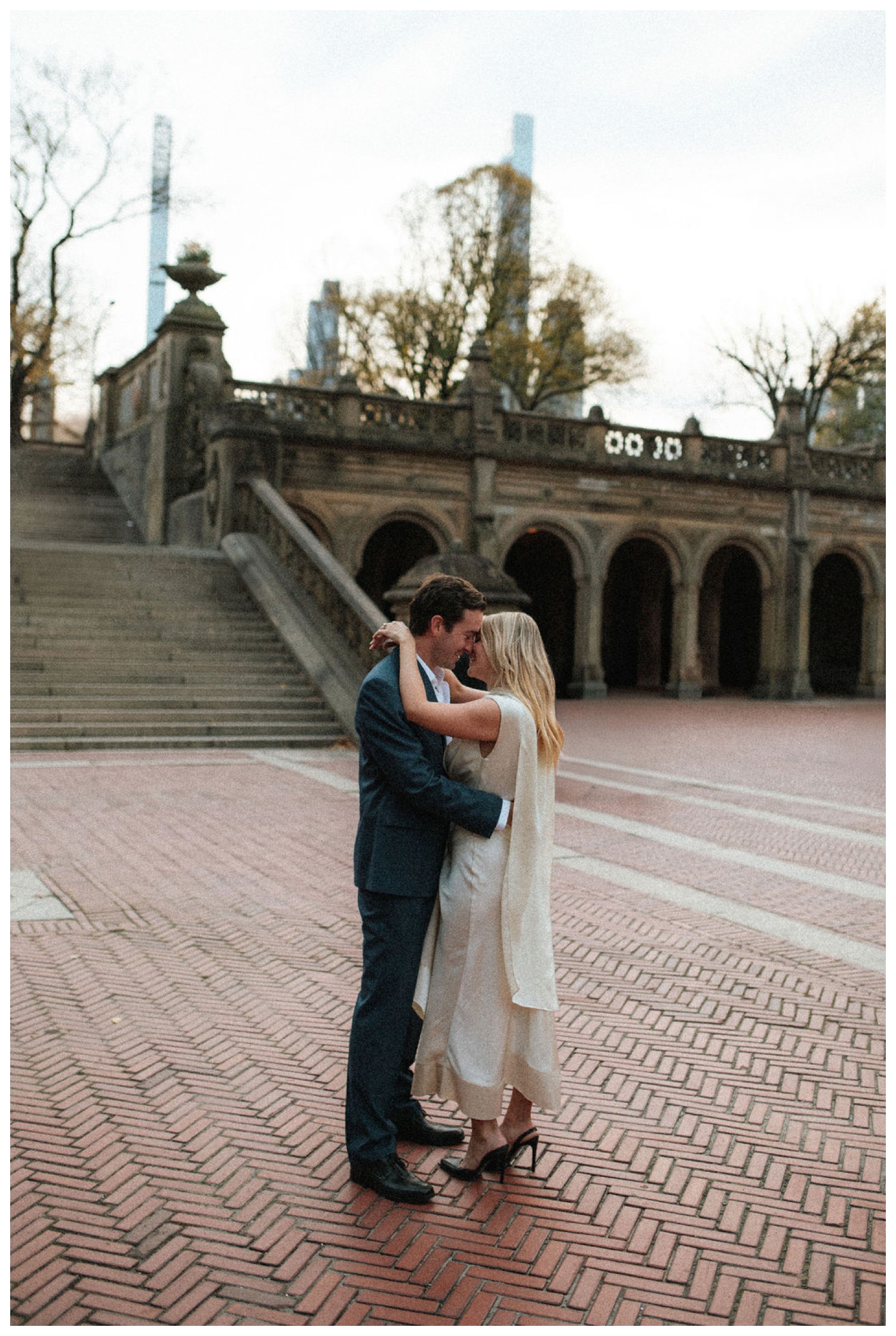 bride and groom at bethesda terrace in central park for an engagement session. NYC wedding photographer.