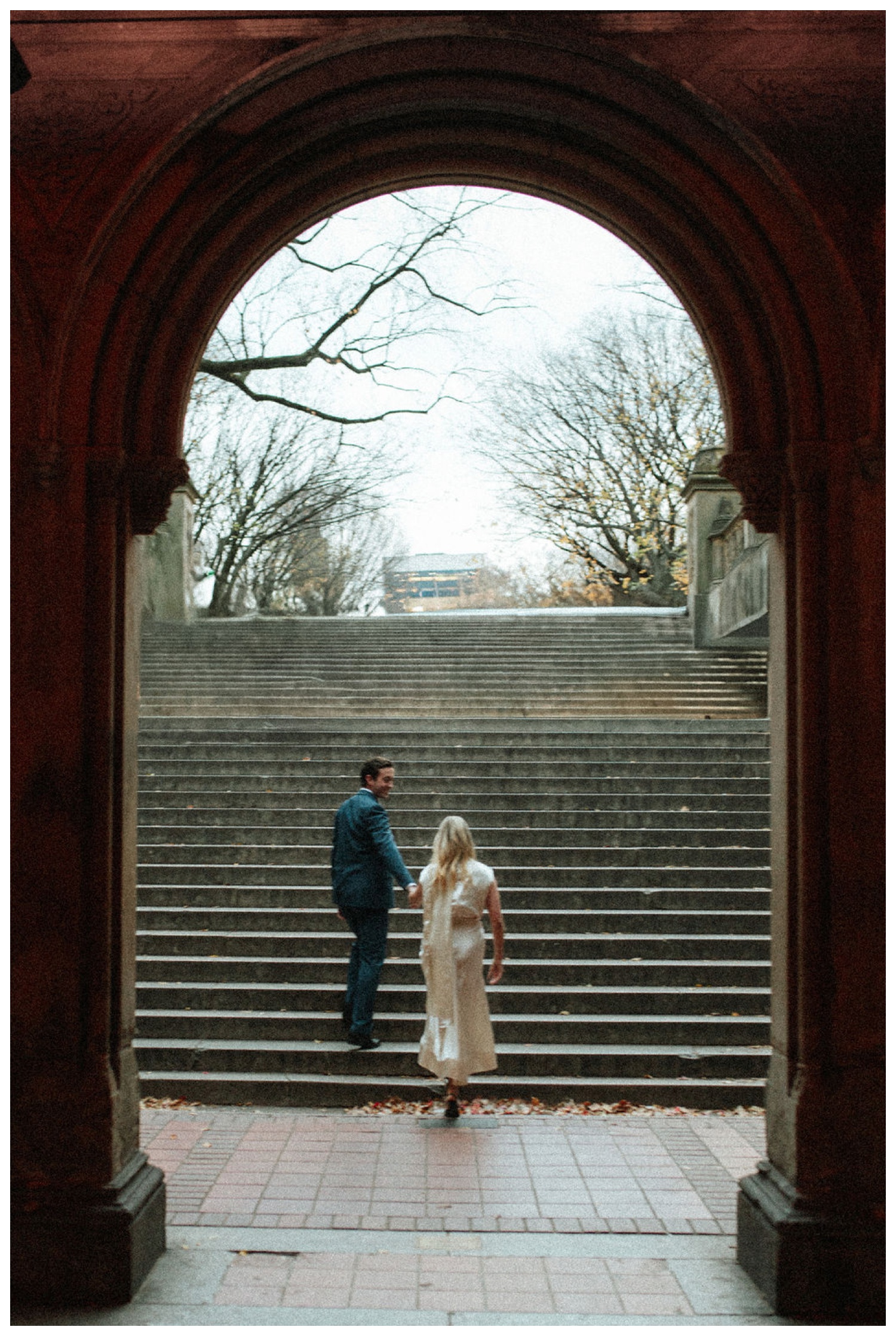 bride and groom at bethesda terrace in central park for an engagement session. NYC wedding photographer.