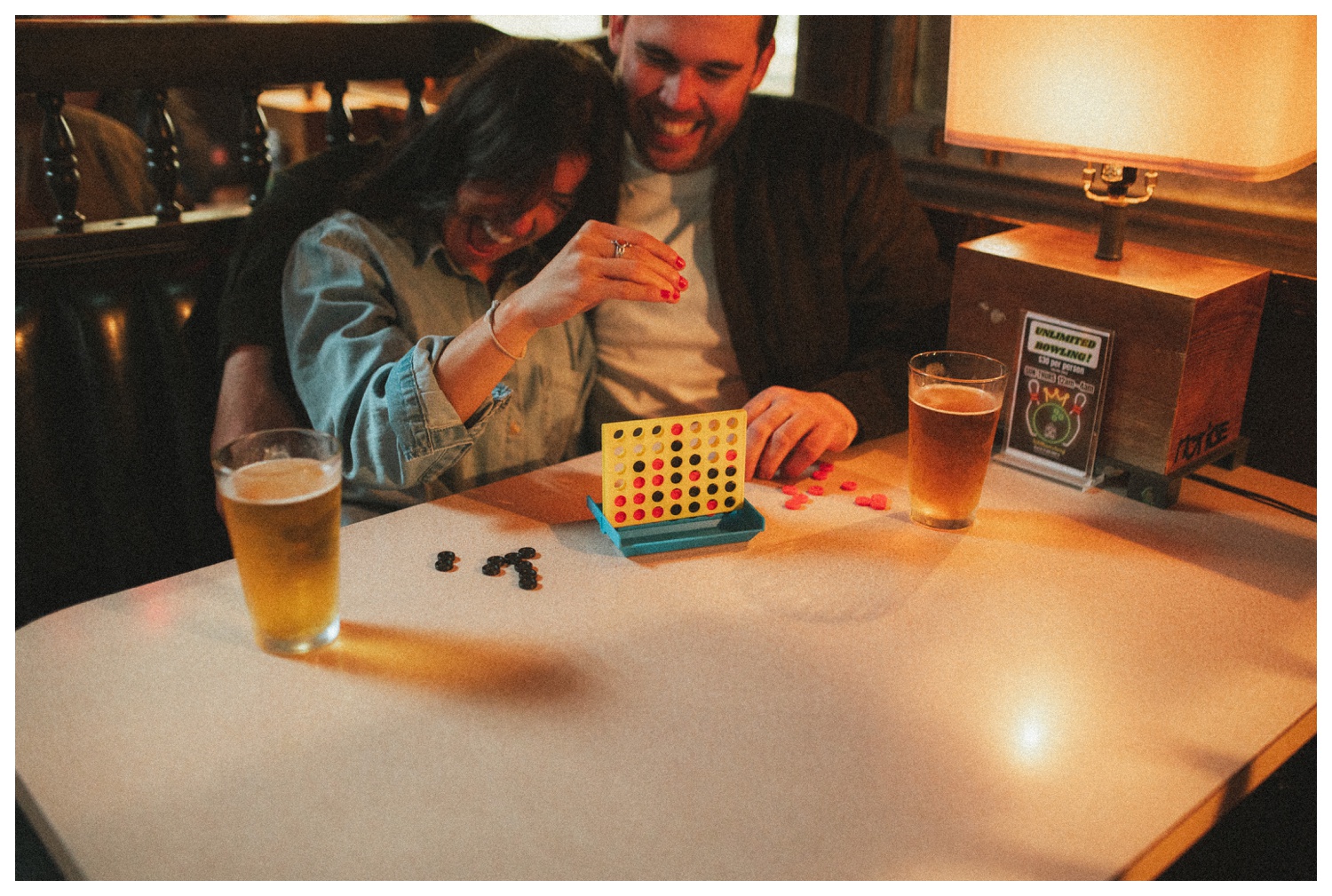 Engaged couple playing Connect Four at THE GUTTER bowling alley for their engagement session in Williamsburg Brooklyn. Brooklyn Wedding Photographer. Parr Photo Co