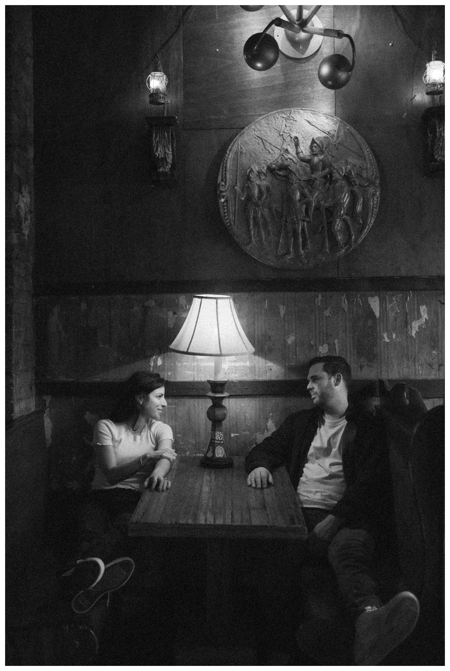 Engaged couple sitting in a bar under red light in Greenpoint Brooklyn. Brooklyn Wedding Photographer. Parr Photo Co