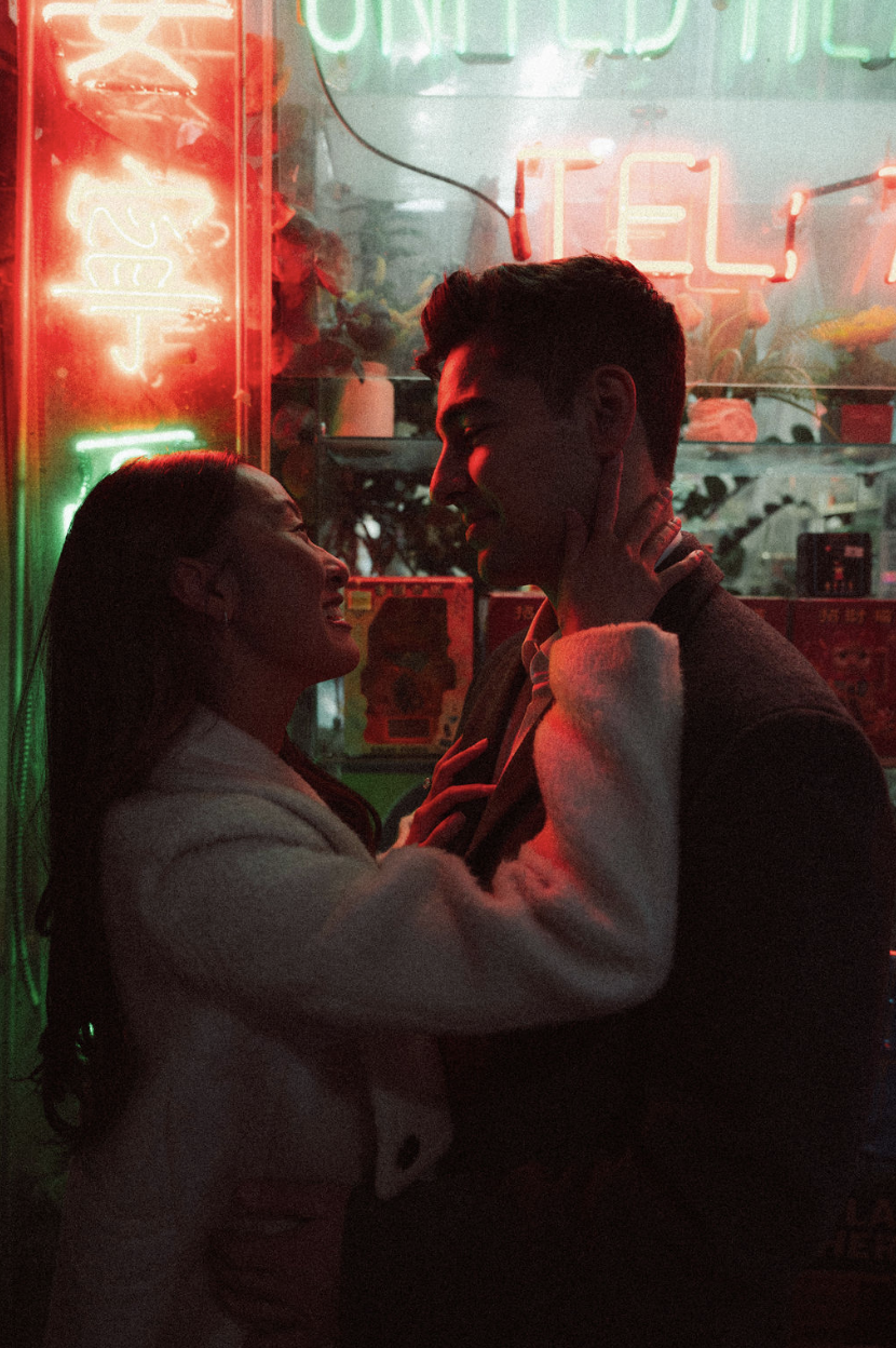 A bride and groom face to face in front of neon signs in Chinatown at night for their engagement session. Parr Photo Co. Manhattan wedding photographer. Brooklyn wedding photographer.