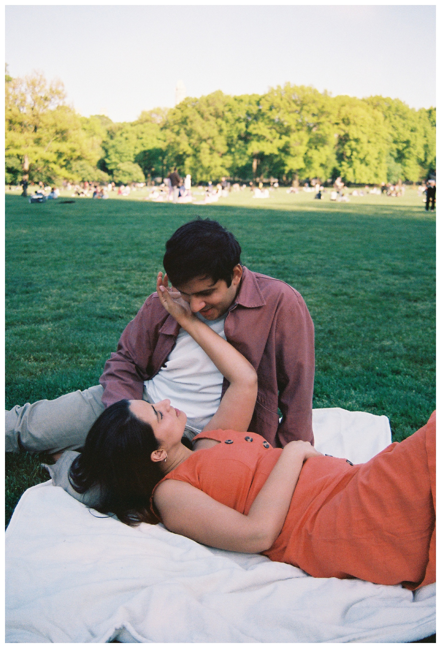 A film photo of a couple sitting on a blanket at Sheep Meadow in Central Park NYC. Parr Photo Co. NYC wedding photographer. Brooklyn Wedding Photographer.