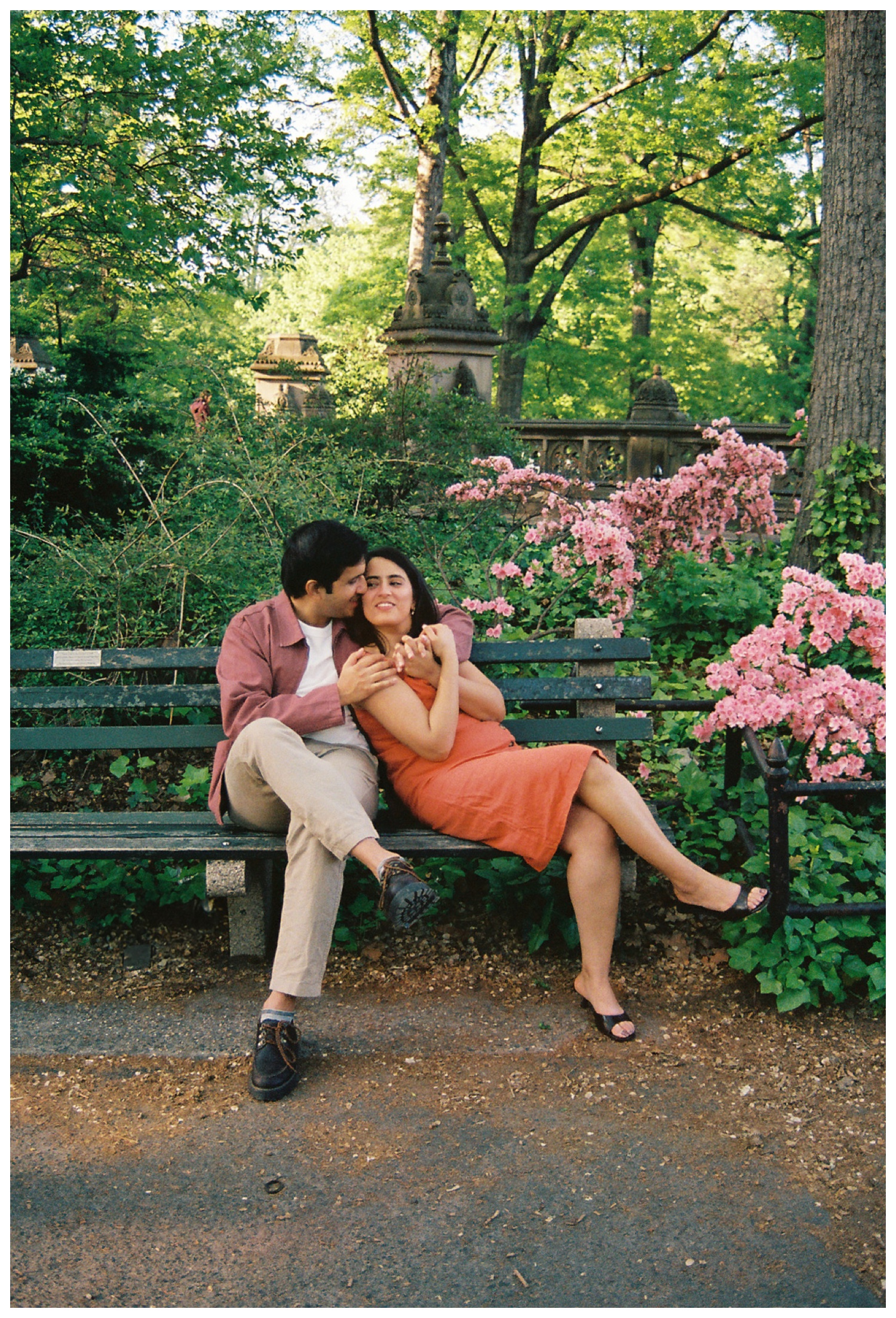 A film photos of a cinematic moment of a couple sitting on the bench, hugging at the iconic and cinematic Central Park on the upper west side. NYC Wedding Photographer. Parr Photo Co.