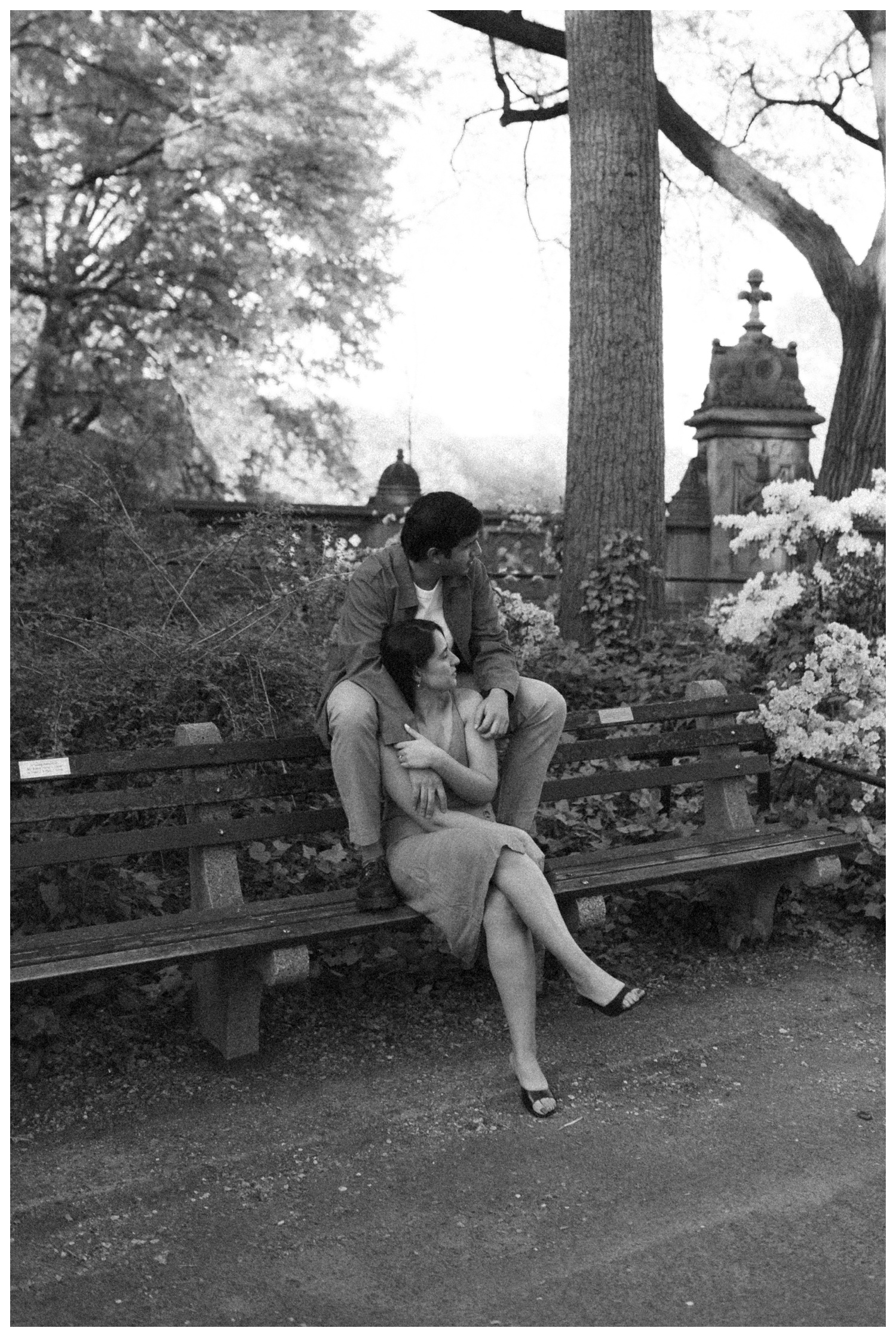 A couple sitting on the bench, hugging at the iconic and cinematic Central Park on the upper west side. NYC Wedding Photographer. Parr Photo Co.