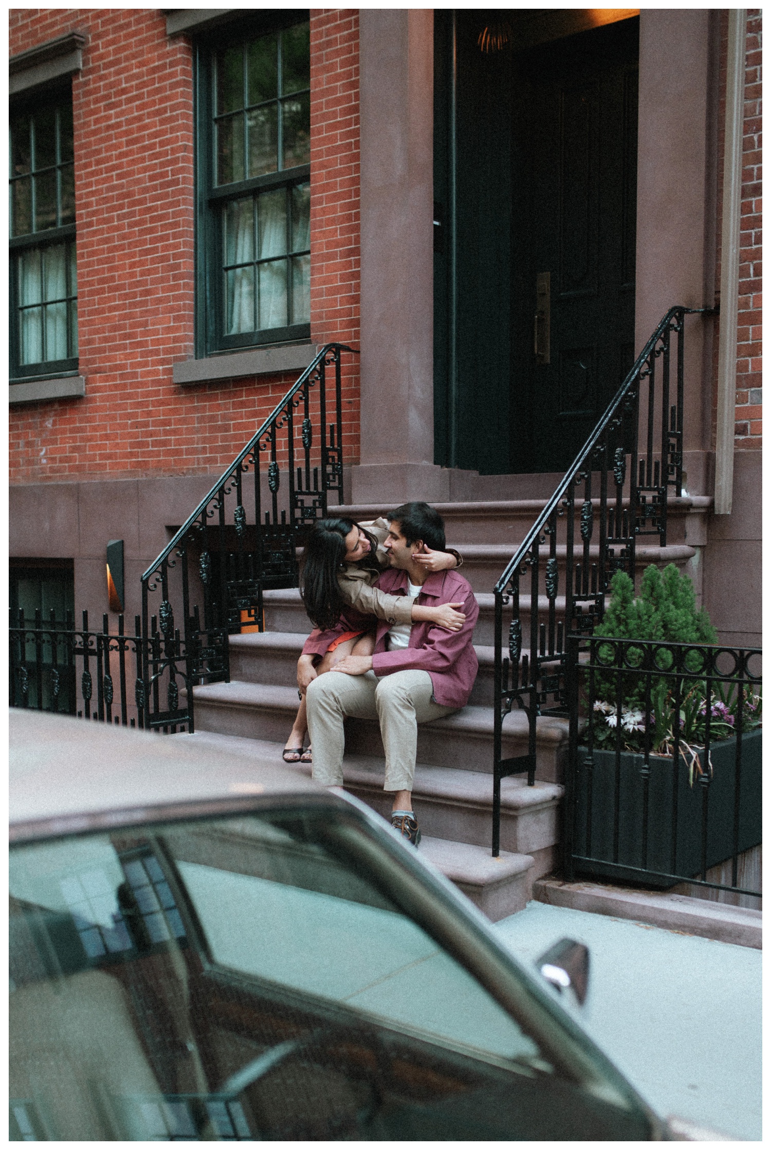 A couple kissing on the steps of a brownstone on the cinematic streets of the West Village. NYC Wedding Photographer. Brooklyn Wedding Photographer.