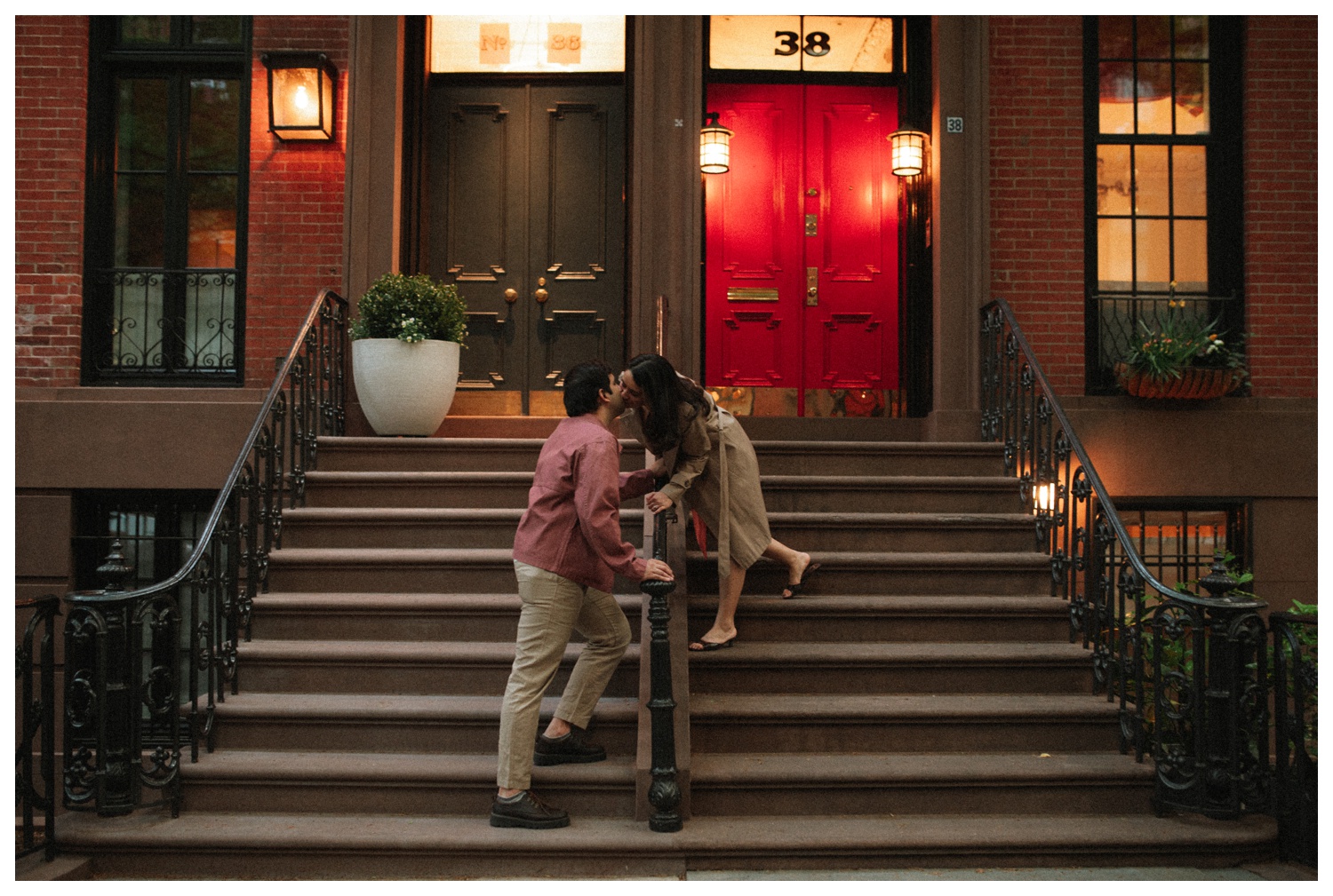 A couple kissing on the steps of a brownstone on the cinematic streets of the West Village. NYC Wedding Photographer. Brooklyn Wedding Photographer.