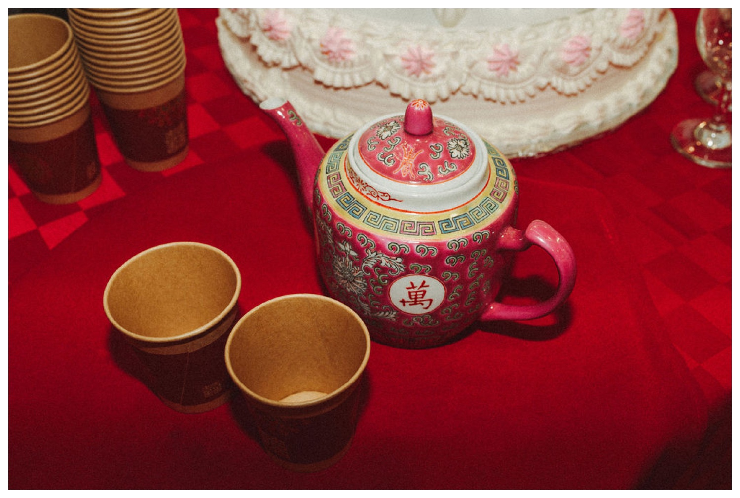 The tea pot and cups used on the red table cloth for serving at the tea ceremony. NYC wedding Photographer. Parr Photo Co
