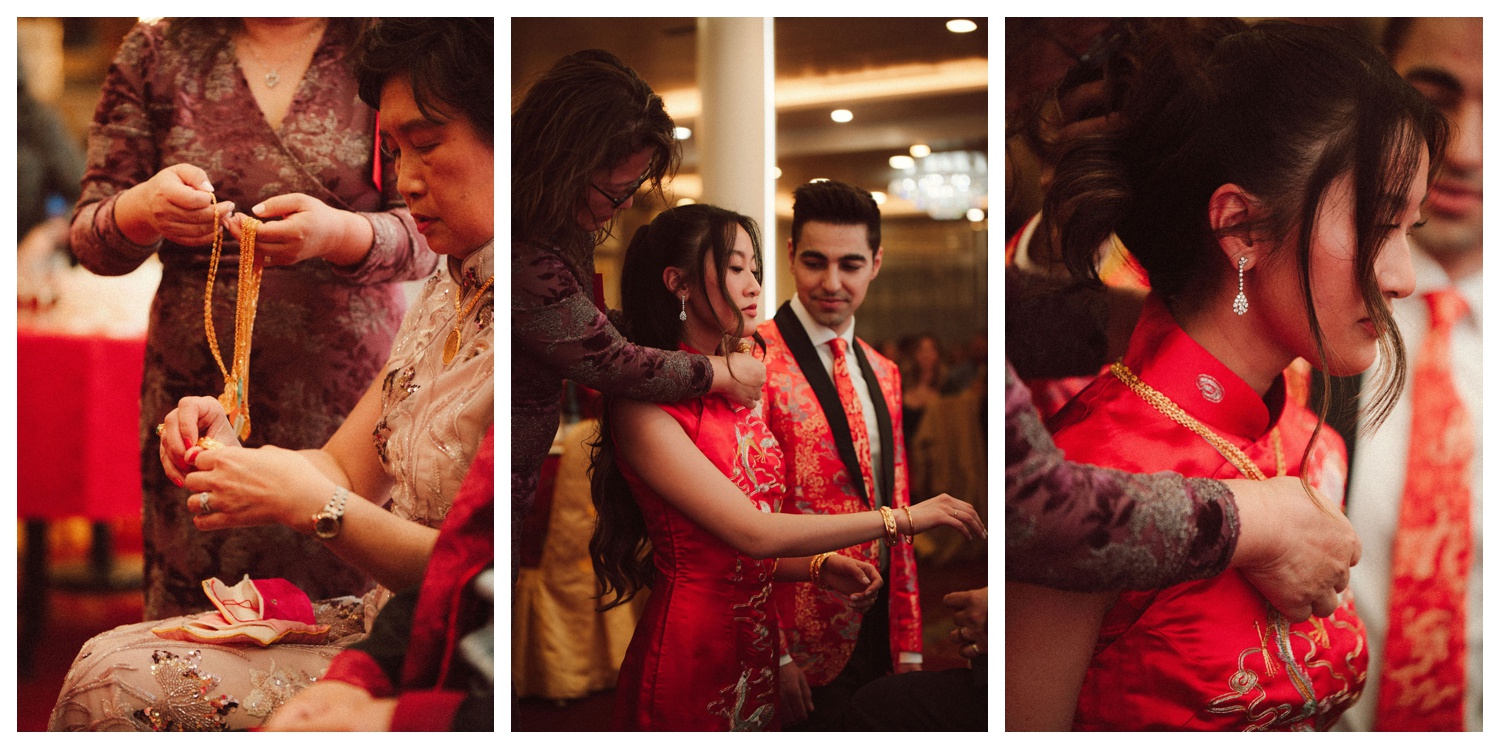 Bride and groom having jewelry placed on them at their tea ceremony in Chinatown NYC as a gift